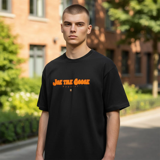 Model wearing a black Joe the Goose Apparel heavy cotton classic tee with orange fat lettering logo outdoors.
