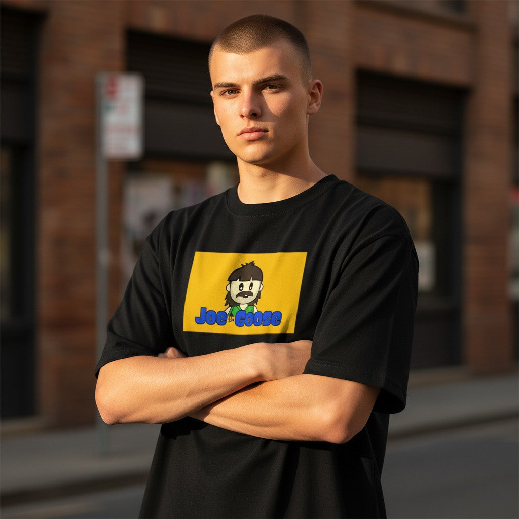 A man wearing a Joe the Goose Apparel black heavy cotton t-shirt with a yellow graphic print on the chest.