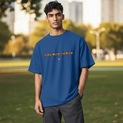 Model wearing a blue Joe the Goose Apparel classic cotton t-shirt with orange circular logo in an outdoor park.