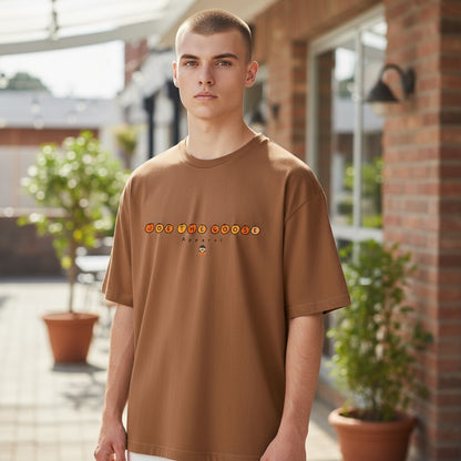 A model wearing a brown Joe the Goose Apparel heavy cotton classic t-shirt with a circular logo graphic.