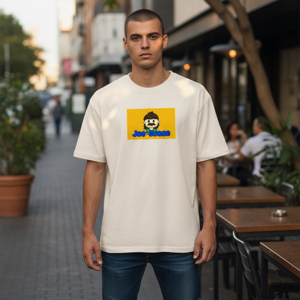 Man wearing a Joe the Goose Apparel heavy weight cotton t-shirt with a yellow graphic print on a city sidewalk.