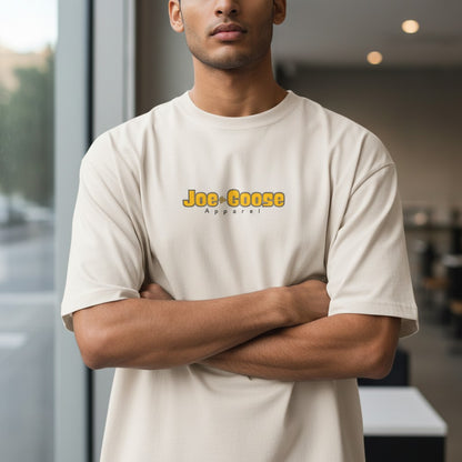A man wearing a Joe the Goose Apparel heavy weight cream cotton t-shirt with a relaxed fit and dropped shoulders.