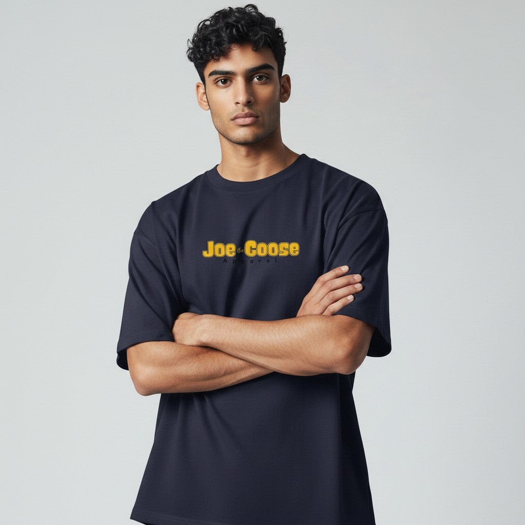 Model wearing a Joe the Goose Apparel navy heavy cotton tee with a relaxed fit and yellow logo graphic.