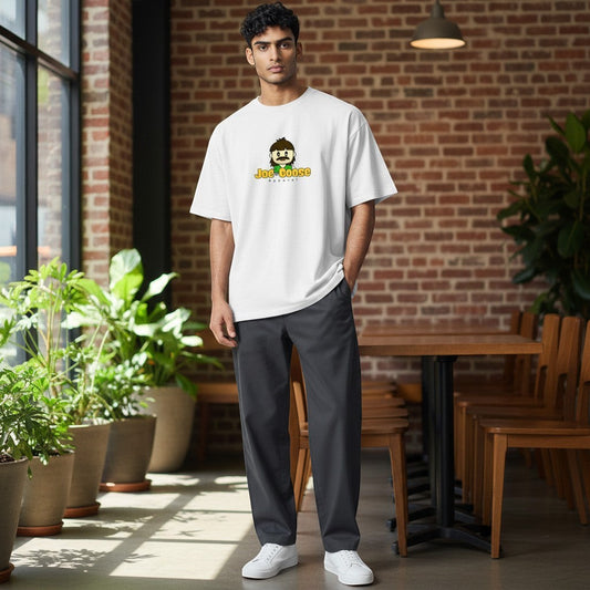 Model wearing a Joe the Goose Apparel white heavy cotton t-shirt with a relaxed fit in a modern cafe setting.